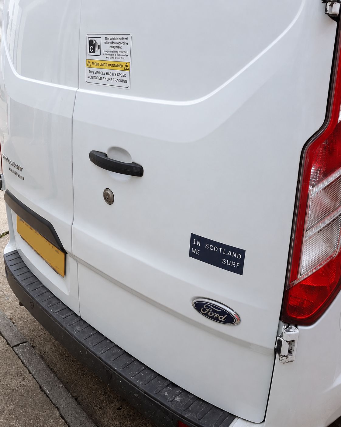Close-up of the same Ford Transit Custom rear door after refinishing, showing an even white finish around the handle, badge and lower door edge