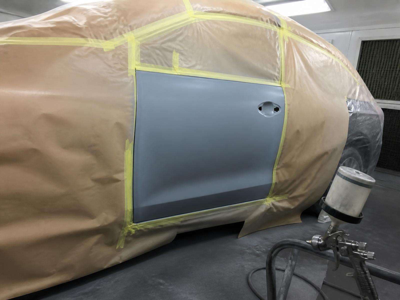 Car masked up with a primed door panel ready for paint